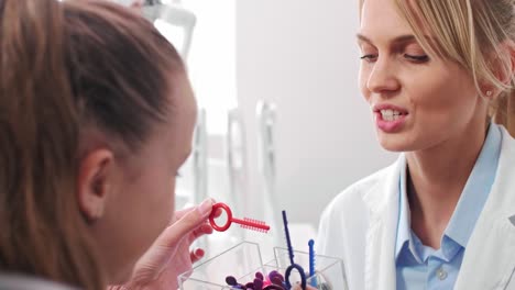 teenage girl choosing the color of rubber bands for braces