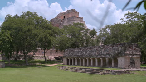 estableciendo una vista de mano de la pirámide del mago en uxmal, yucatán, rodeada de exuberante vegetación