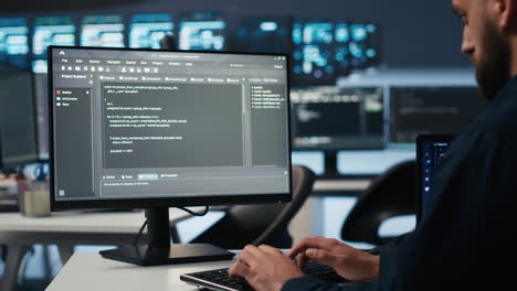 IT employee programming in server hub housing supercomputers storing datasets