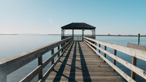 walking to end of pier over glassy clear harbor