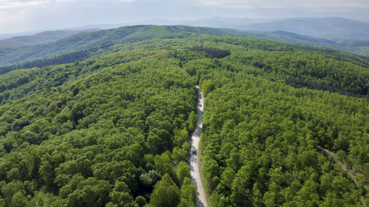Tilting drone shot of a rough terrain of an off-road route leading up to the Golyamo Gradishte Peak on Strandzha Mountain in a Bulgarian countryside.