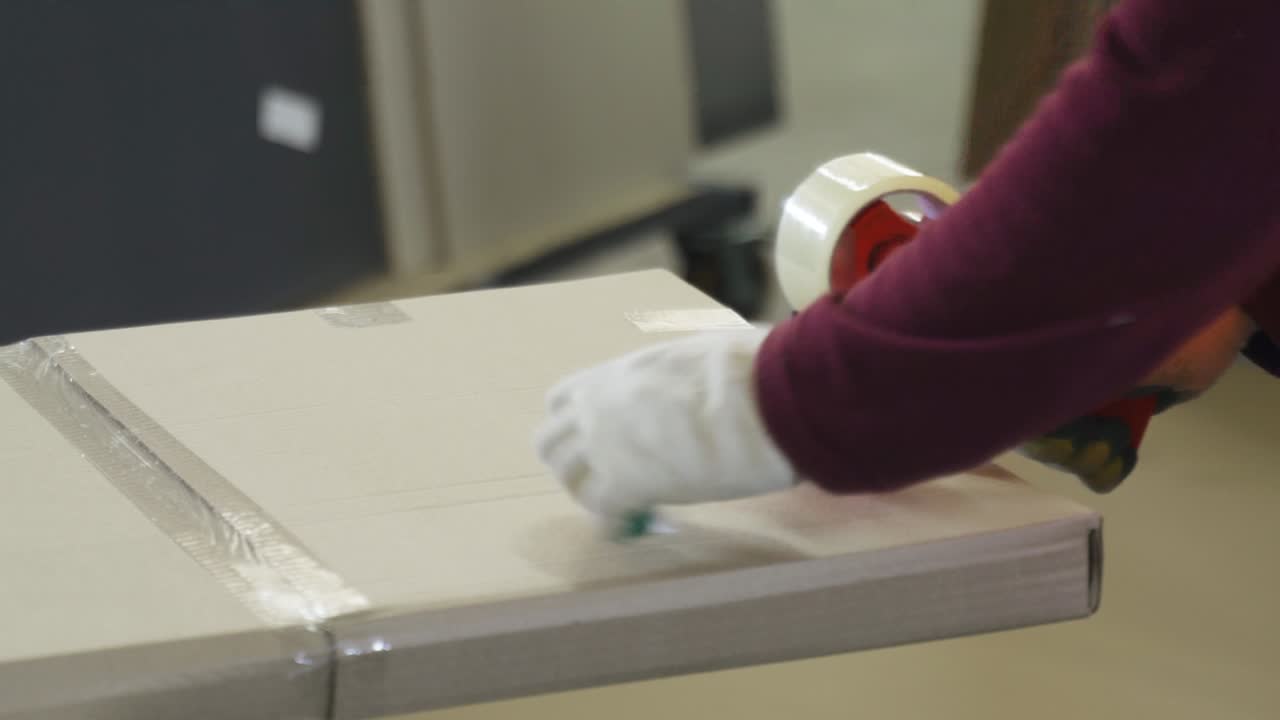 Packaging of furniture boards in cardboard and gluing with adhesive tape.