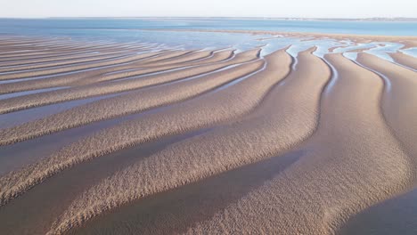 textured golden sand dunes with leading lines to the blue waters edge