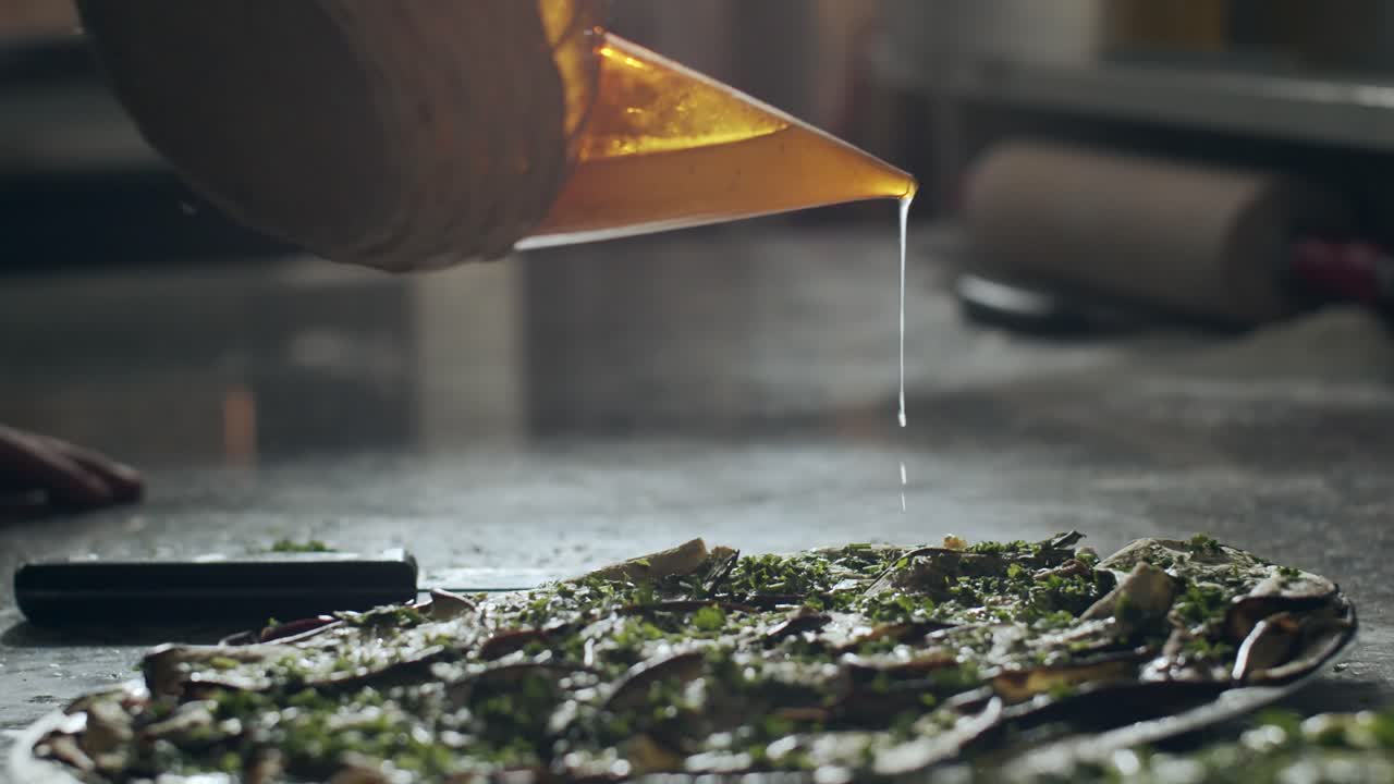 Chef pouring sauce on vegetarian pizza