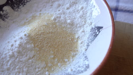 hombre chef mezclando harina y especias para la panadería asiática, el pimentón ahumado y el chile en polvo se han agregado al ajo en polvo y a la harina