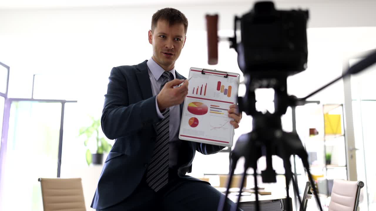 Podnikatel vysílá firemní videokonferenci přes kameru.