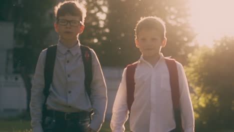 boys-with-backpacks-walk-after-lessons-in-park-slow-motion