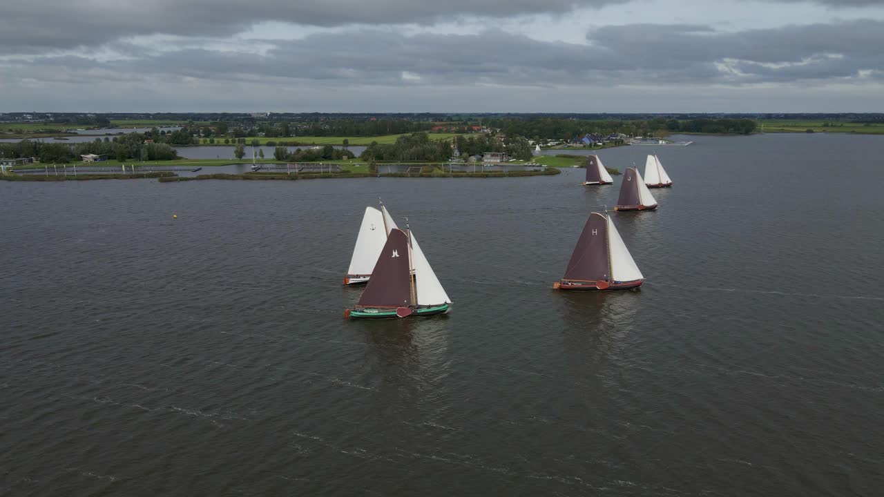 Letecký pohled na plachetnice skutsje soutěžící na jezeře Sneekermeer v Sneeku, Frísko, Nizozemsko.