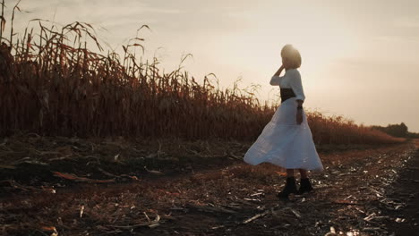 farmer in a dress and hat walks in a field of ripe corn 9