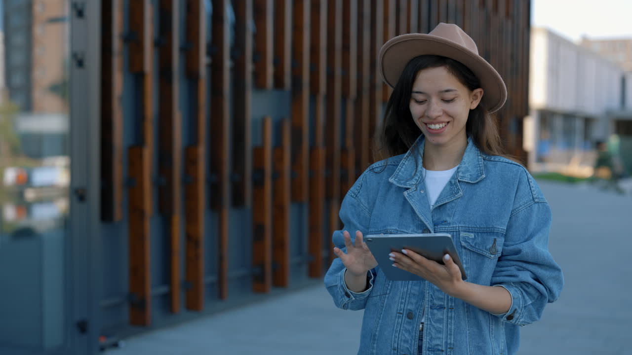 Young Woman Using Tablet Outside Modern Building