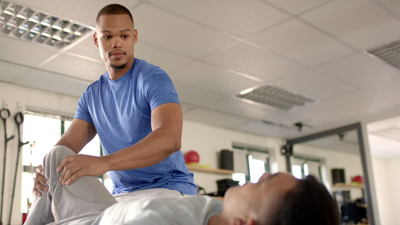 Assisting patient with leg exercises, physical therapist during rehabilitation session