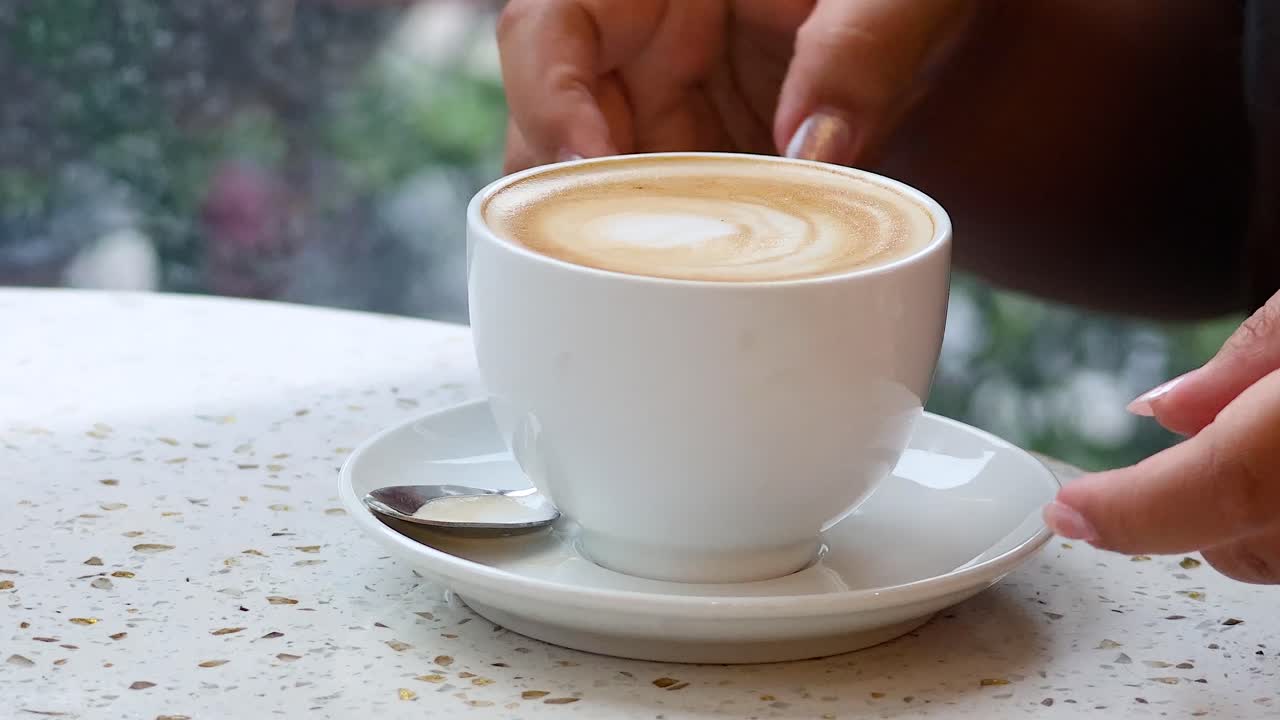 Hand stirring coffee in a Hanoi cafe