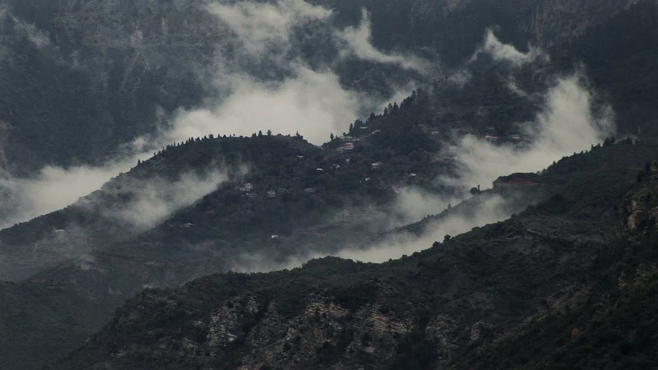 las nubes se forman alrededor de un pequeño pueblo en una montaña en grecia