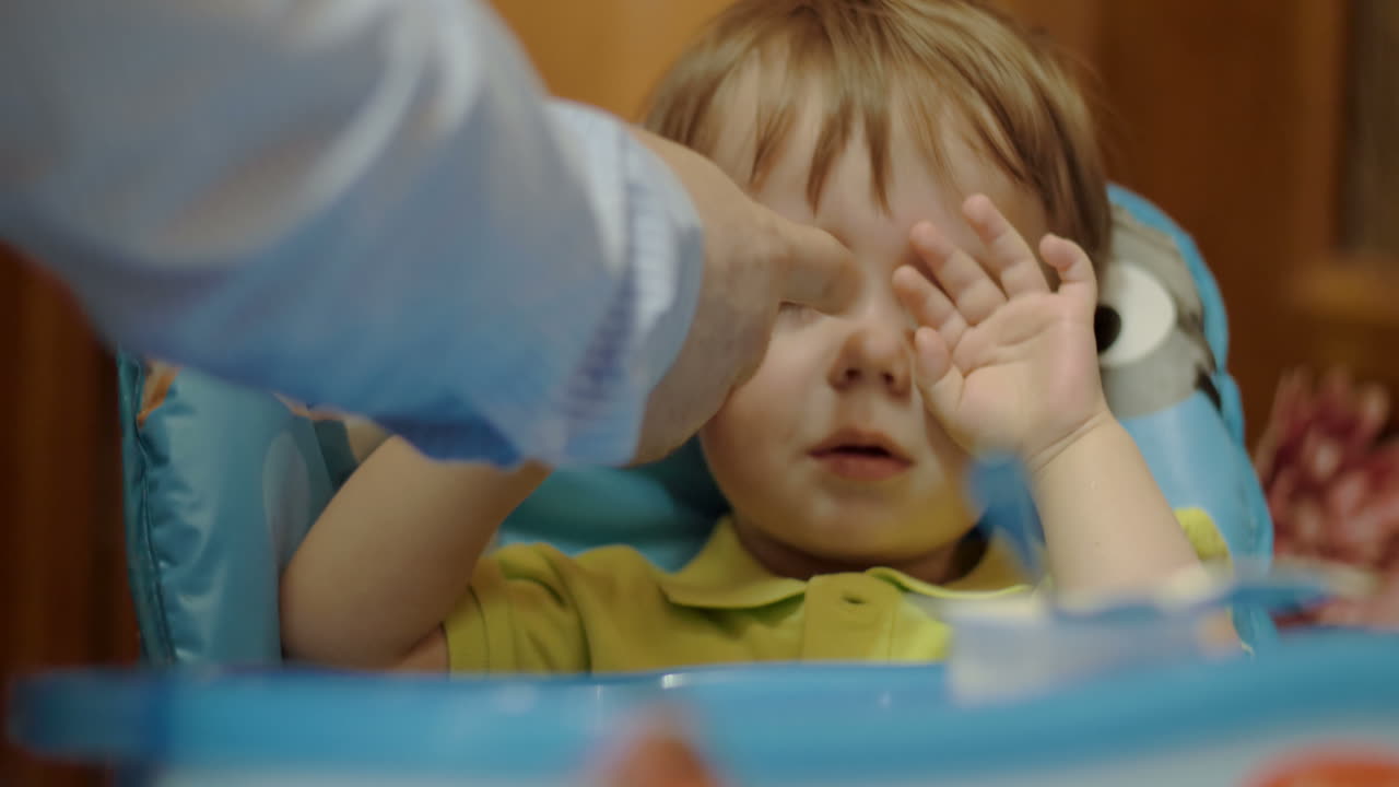 сонный и уставший мальчик ужинает с молочными продуктами