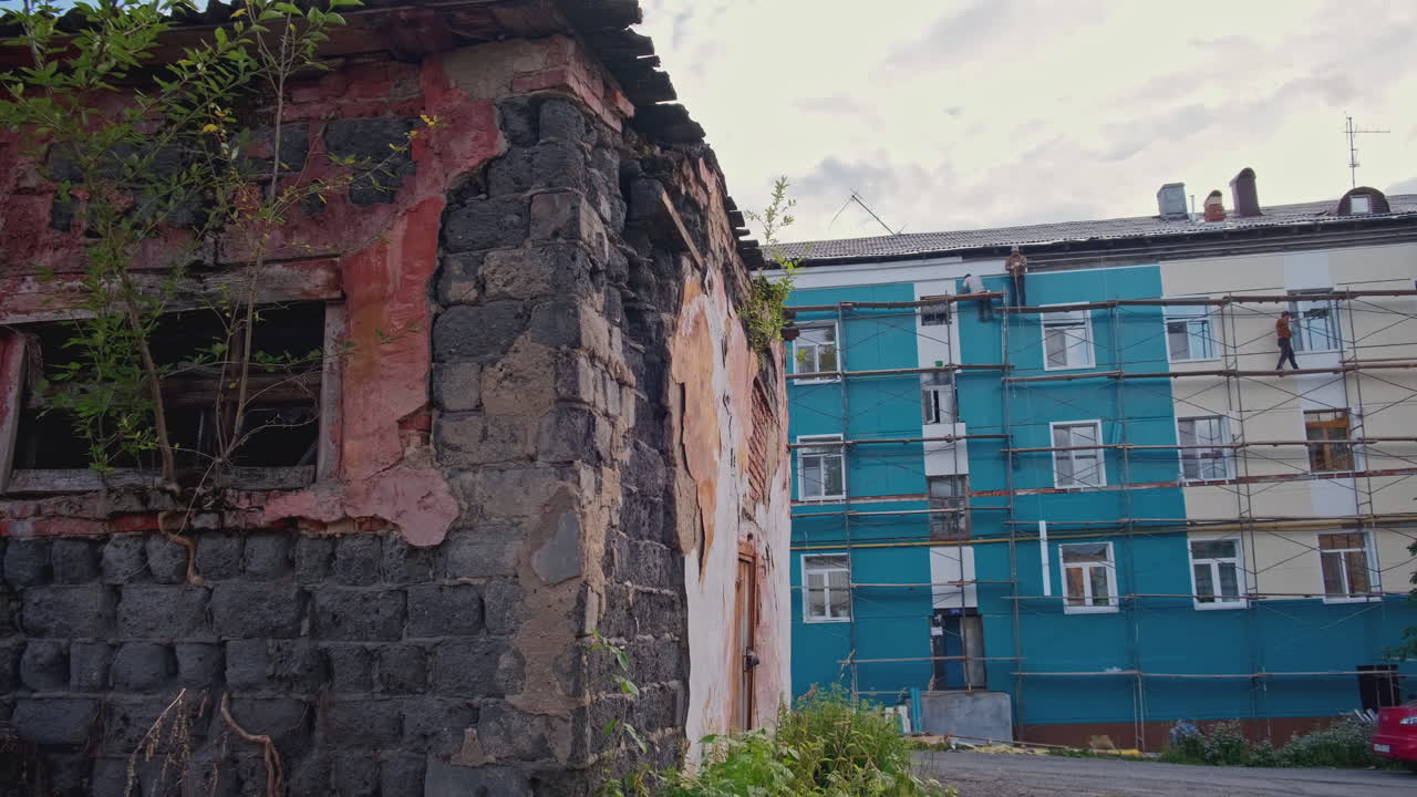 renovación de un edificio de apartamentos junto a una casa vieja en ruinas