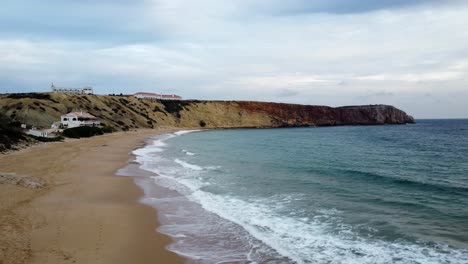 Moving-left-drone-shot-of-a-landscape-with-a-5-star-Hotel-on-the-shore-in-Portugal-facing-the-atlantic-ocean