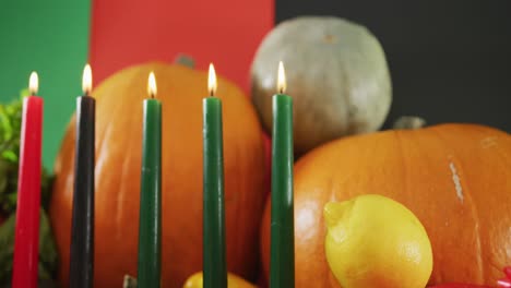 Composition-of-six-lit-candles-and-halloween-pumpkins-and-vegetables