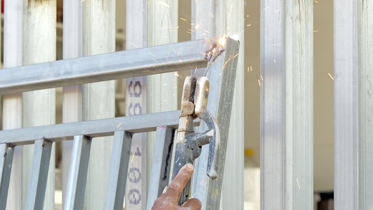 Un'azione dettagliata di pittura di un cancello di metallo evidenzia la maestria artigianale in un'officina