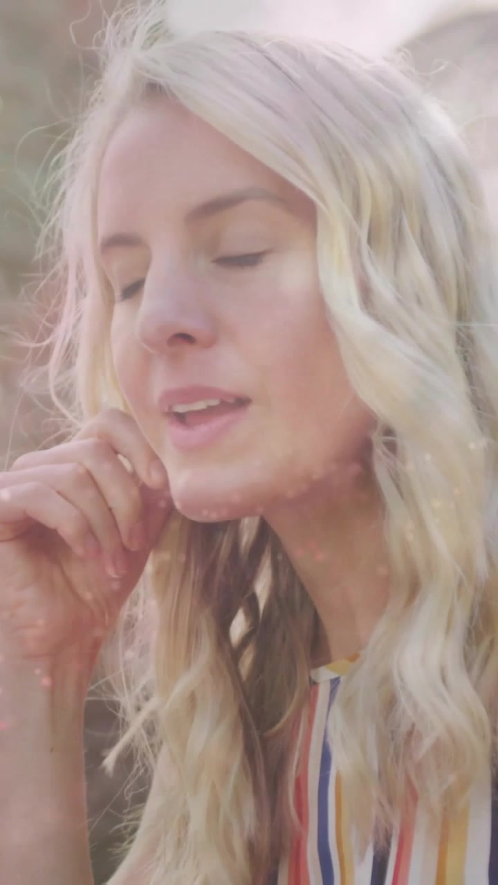 Video verticale: Donna che pensa in giardino con il sole che si sposta e un effetto scintillante sovrapposto al viso per il branding.