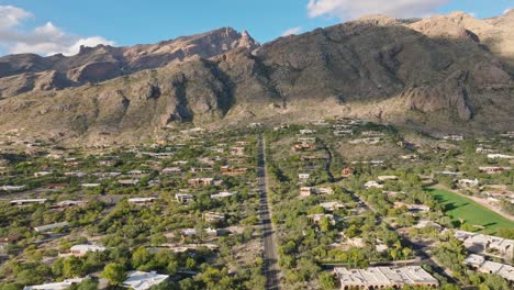 estribaciones soleadas de catalina en tucson arizona, toma de drones del vecindario, campo de golf y cordillera con cielo azul en el fondo