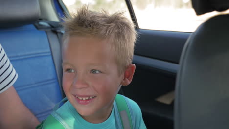 happy little child with backpack traveling by car