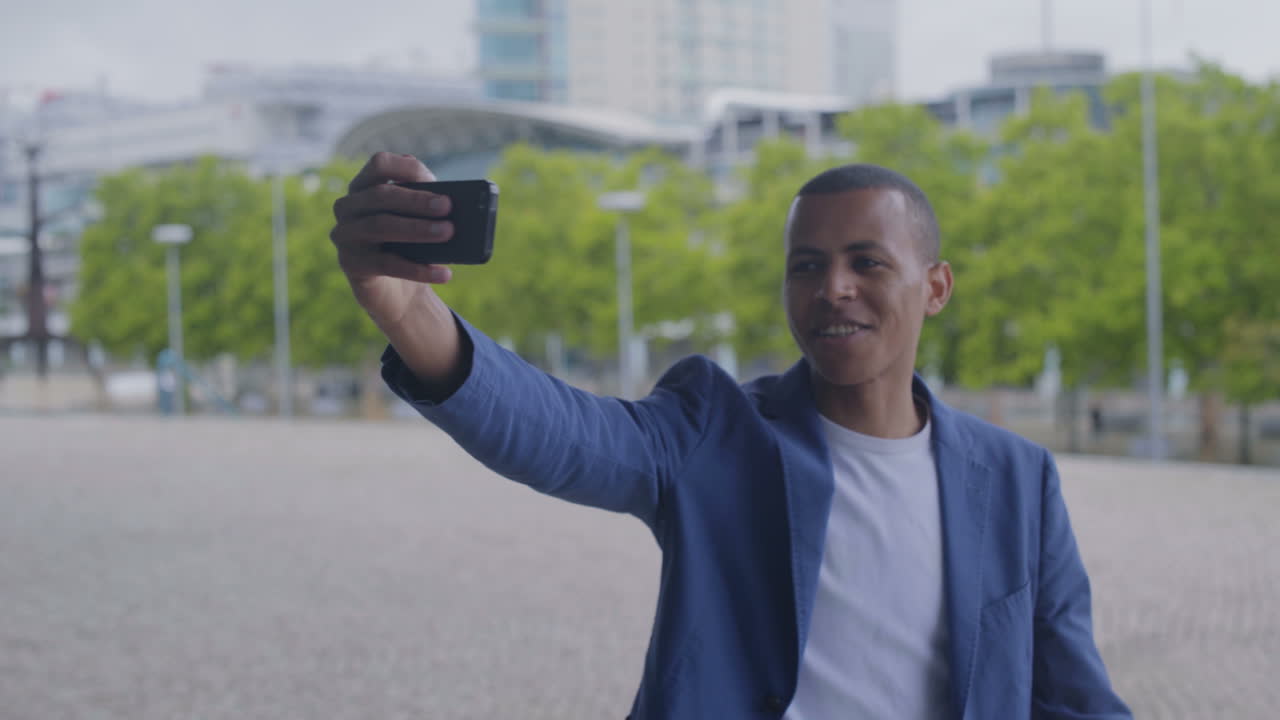 Smiling African American man having video call through smartphone.