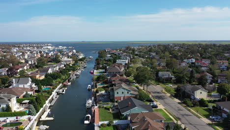 An-aerial-drone-shot-over-a-channel-leading-out-to-East-Bay-on-Long-Island,-NY