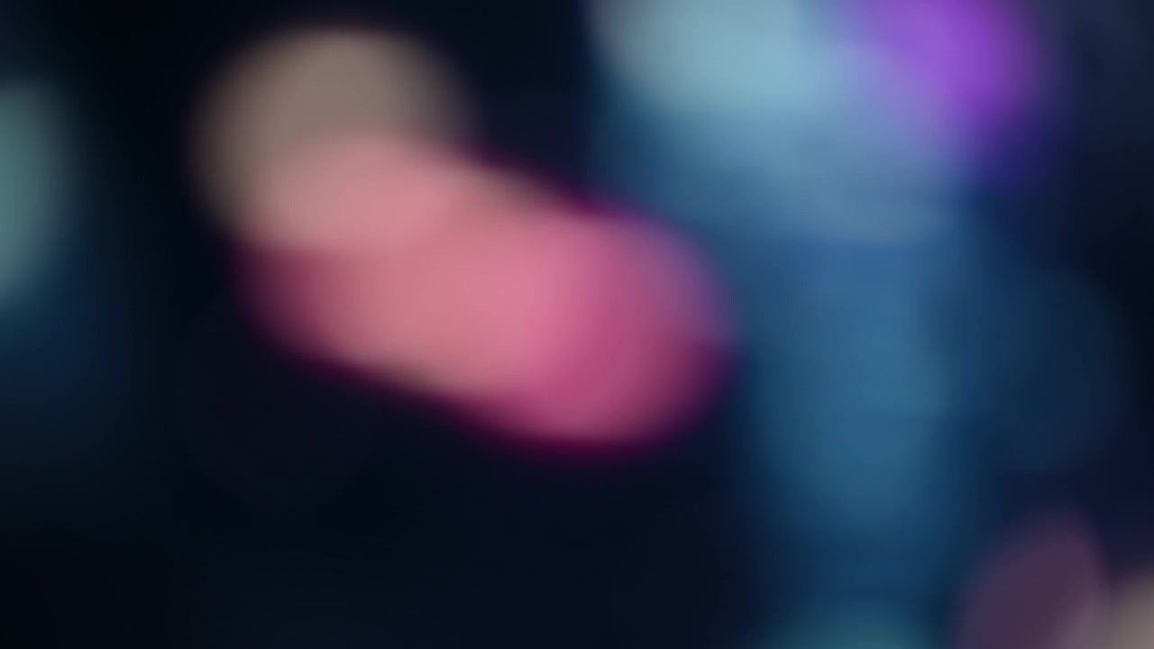 Sfondo bokeh scuro con luci viola e rosa.