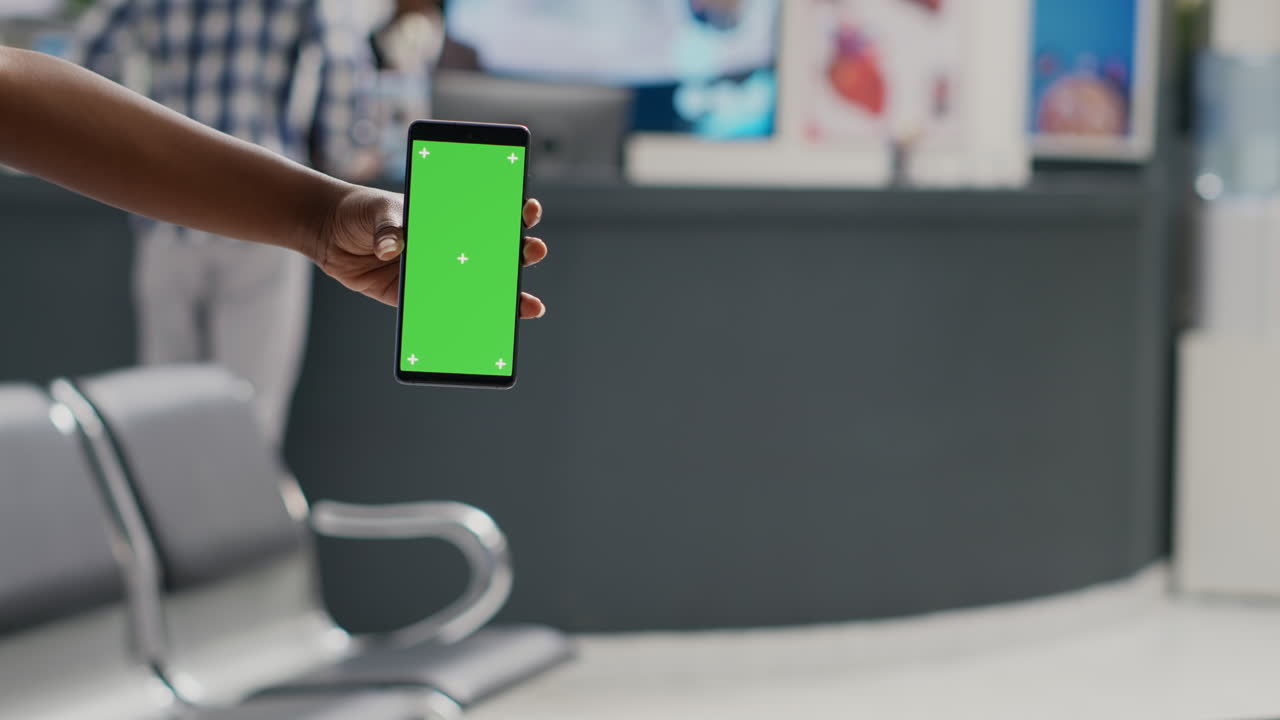 Infermiera professionista che tiene in mano un telefono cellulare con greenscreen