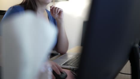 Determined woman in a business casual outfit, focused on laptop