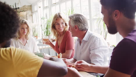 Un-Grupo-De-Edad-Mixta,-Multiétnico-De-Amigos-Adultos-Comiendo-Tapas-Juntos-En-Una-Mesa-En-Un-Restaurante,-De-Cerca,-El-Enfoque-Selectivo