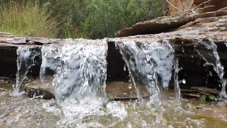 hermosa pequeña cascada de la corriente de agua de manantial de montaña corriendo por enormes losas de piedra arenisca de roca con musgo verde, algas - agua potable cristalina, meditación tranquila y pacífica calmante