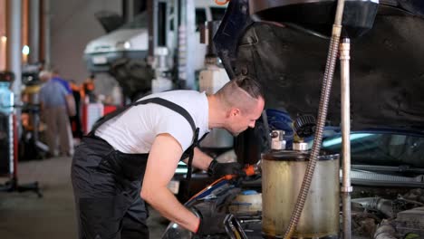 mechanic working on a car engine in an auto repair shop