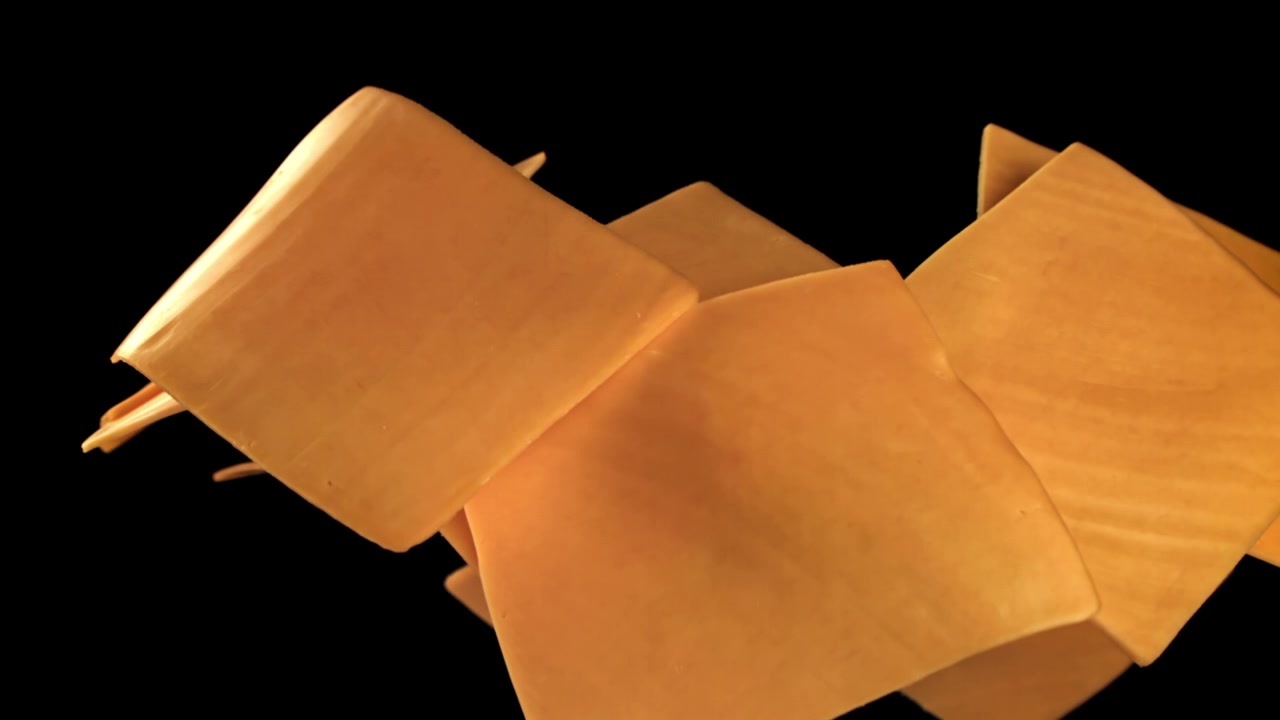 Yellow Cheese Slices Appearing and Disappearing on Black Background