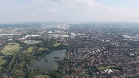 High-drone-shot-of-long-straight-train-tracks-separating-UK-town-from-natural-reserve