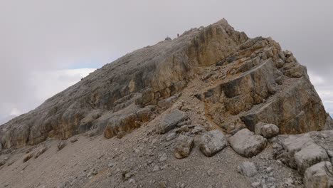 Aerial-forward-view-of-a-peak-of-Monte-Pelmo-with-climbers-on-top-near-a-crucifix