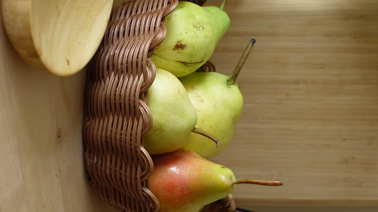 peras en una canasta en una mesa de madera
