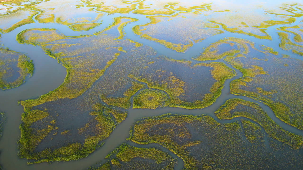 A rotating drone shot view of ocean marshland.
