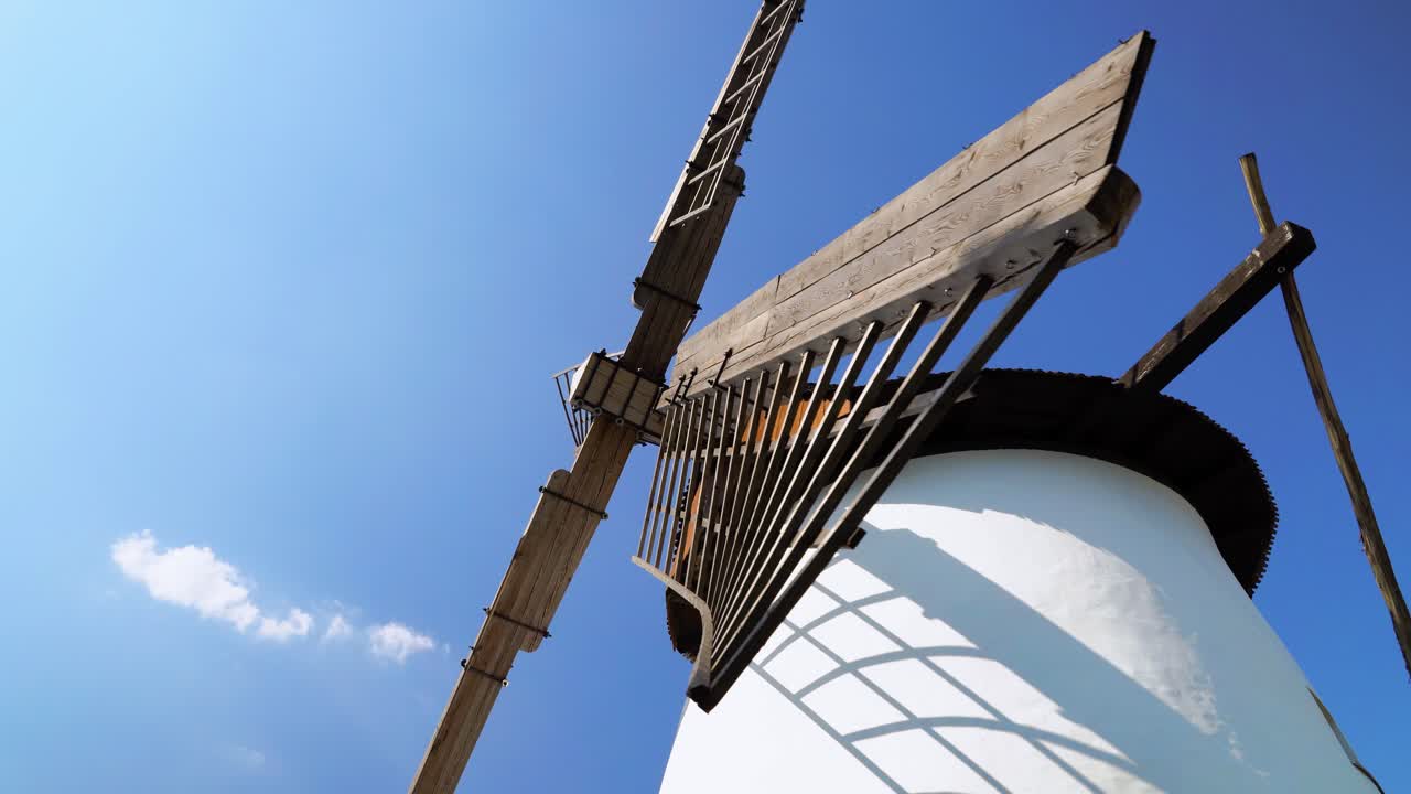 The wooden structure of the blade of a windmill in Hungary with clear, blue sky
