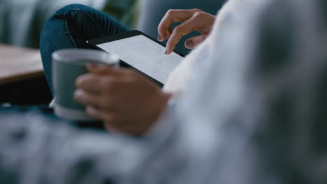 Cerrar-Las-Manos-De-Una-Mujer-Usando-Una-Tableta-Navegando-Por-Las-Redes-Sociales-Revisando-Correos-Electrónicos-En-Un-Dispositivo-Móvil-Con-Pantalla-Táctil-Relajándose-En-Casa-Tomando-Café