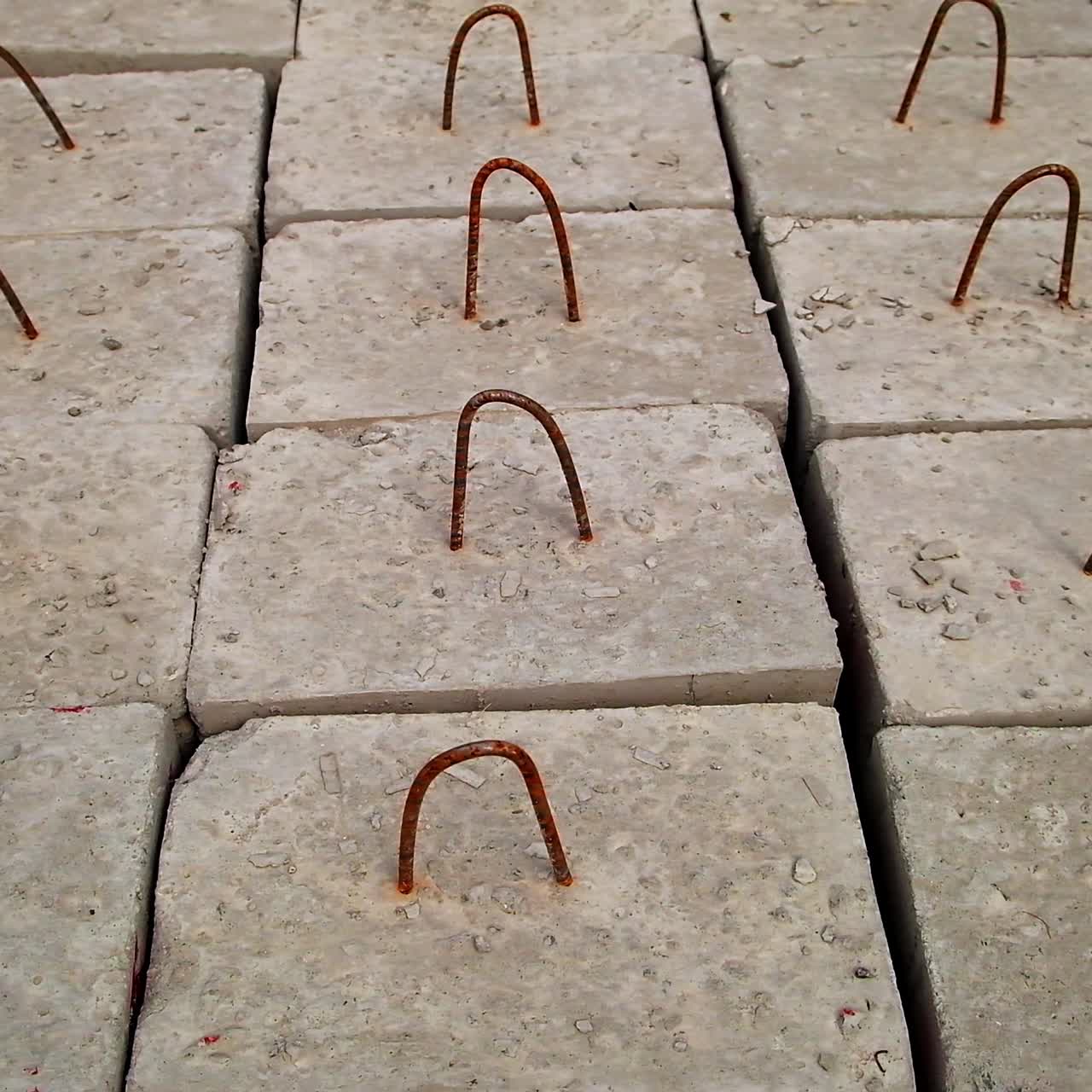 Armored concrete blocks with metal hinges on top. Ferroconcrete bricks left on the ground. View from top. Close up