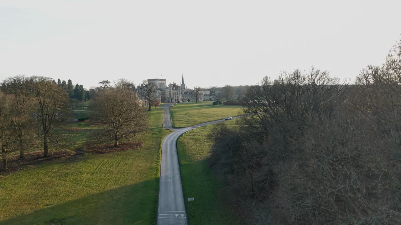 Drone rising from forest path reveals Ashridge House for heritage and nature tourism, Hertfordshire, UK