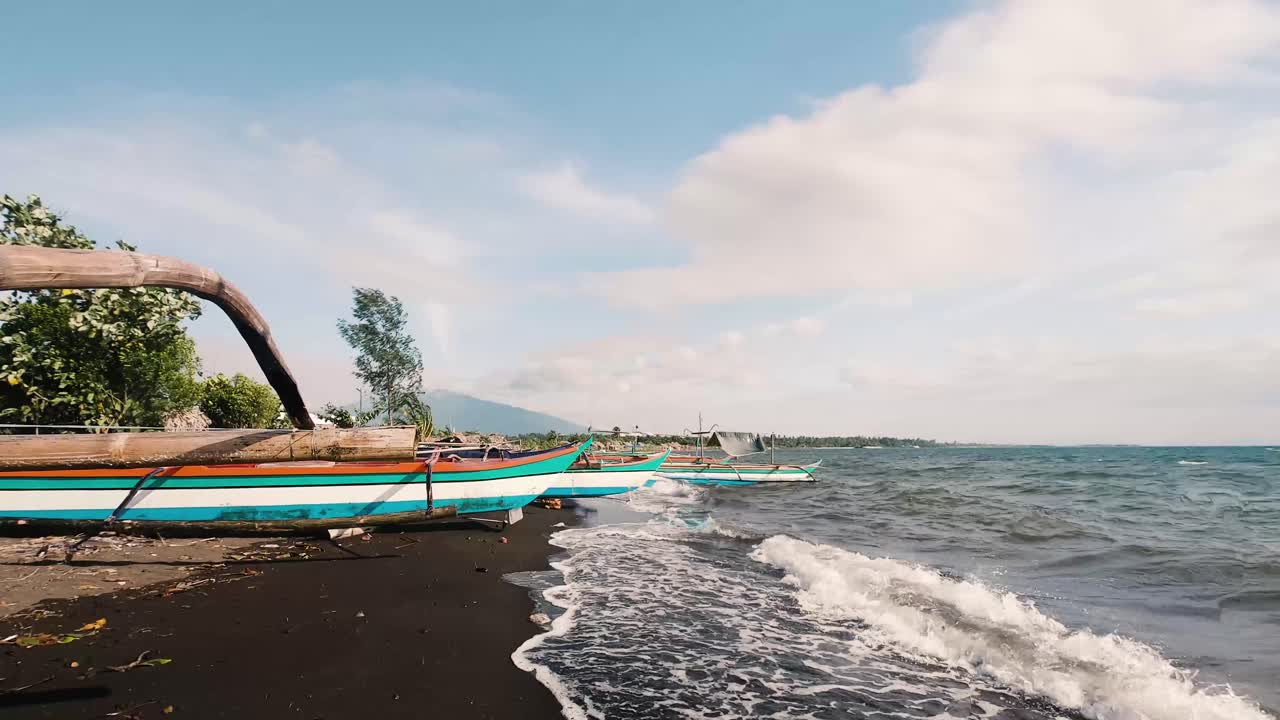 구름이 파도 위로 굴러가는 필리핀 알베이의 팔랄레 해변 옆 전통 어선 - 시간 경과