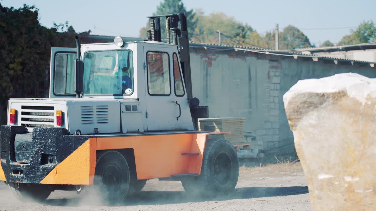 A forklift truck is transporting sandstone slabs at a stone warehouse