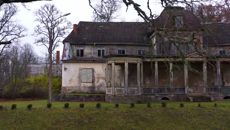 Historical-Burtnieki-Manor-on-moody-day-in-Latvia,-aerial-side-fly-view