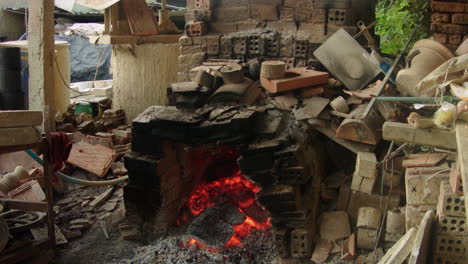 thanh ha pottery village in quang nam, vietnam, showcases traditional pottery-making techniques using a wooden-fired oven and fire pokers, amidst the chaos of the production process