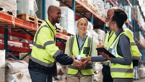 a group of diverse warehouse workers shake hands and smile during a meeting