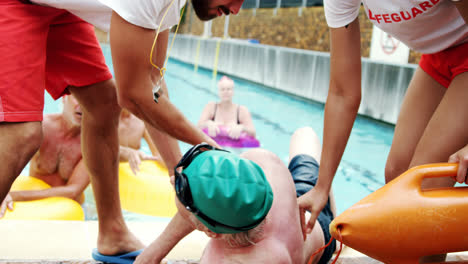 lifeguards assisting unconscious man