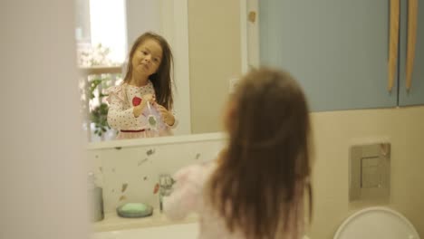 una niña joven cepillándose los dientes en un baño brillante, practicando la higiene oral diaria. ideal para conceptos de salud, rutinas infantiles, higiene y cuidado personal.