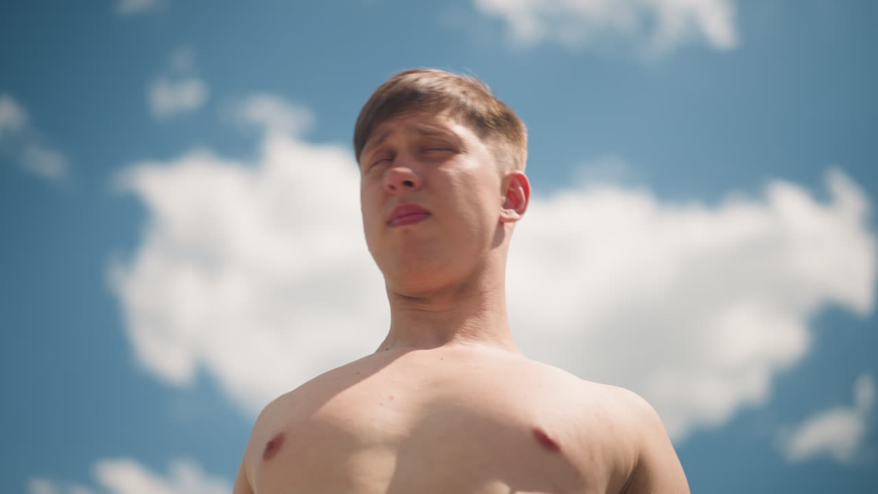 한 남자가 빛나는 낮 하늘을 신중하게 바라보고 있어요. 턱수염을 기른 남자가 밝은 낮의 하늘을 깊이 응시하고, 얼굴에 털이 있는 남자가 화창한 대낮에 밝은 하늘을 생각에 잠겨 바라보고 있습니다.